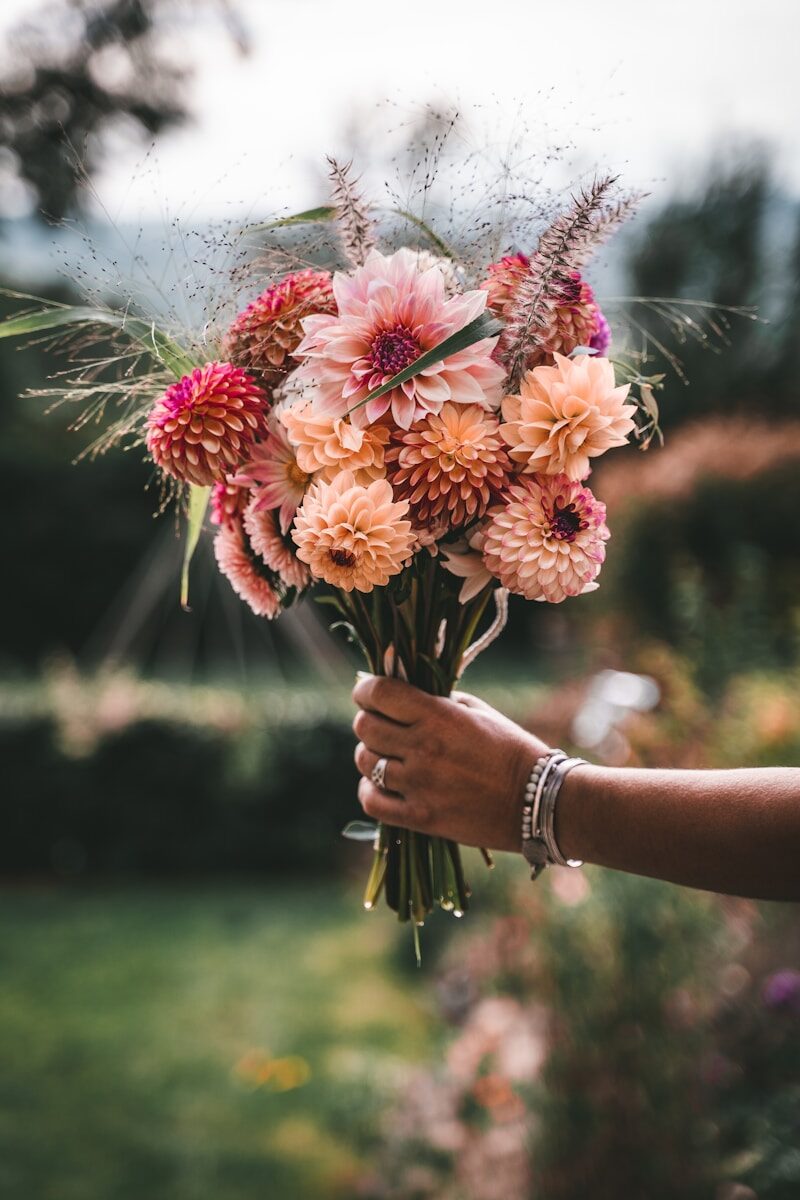 Accueil a person holding a bunch of flowers in their hand