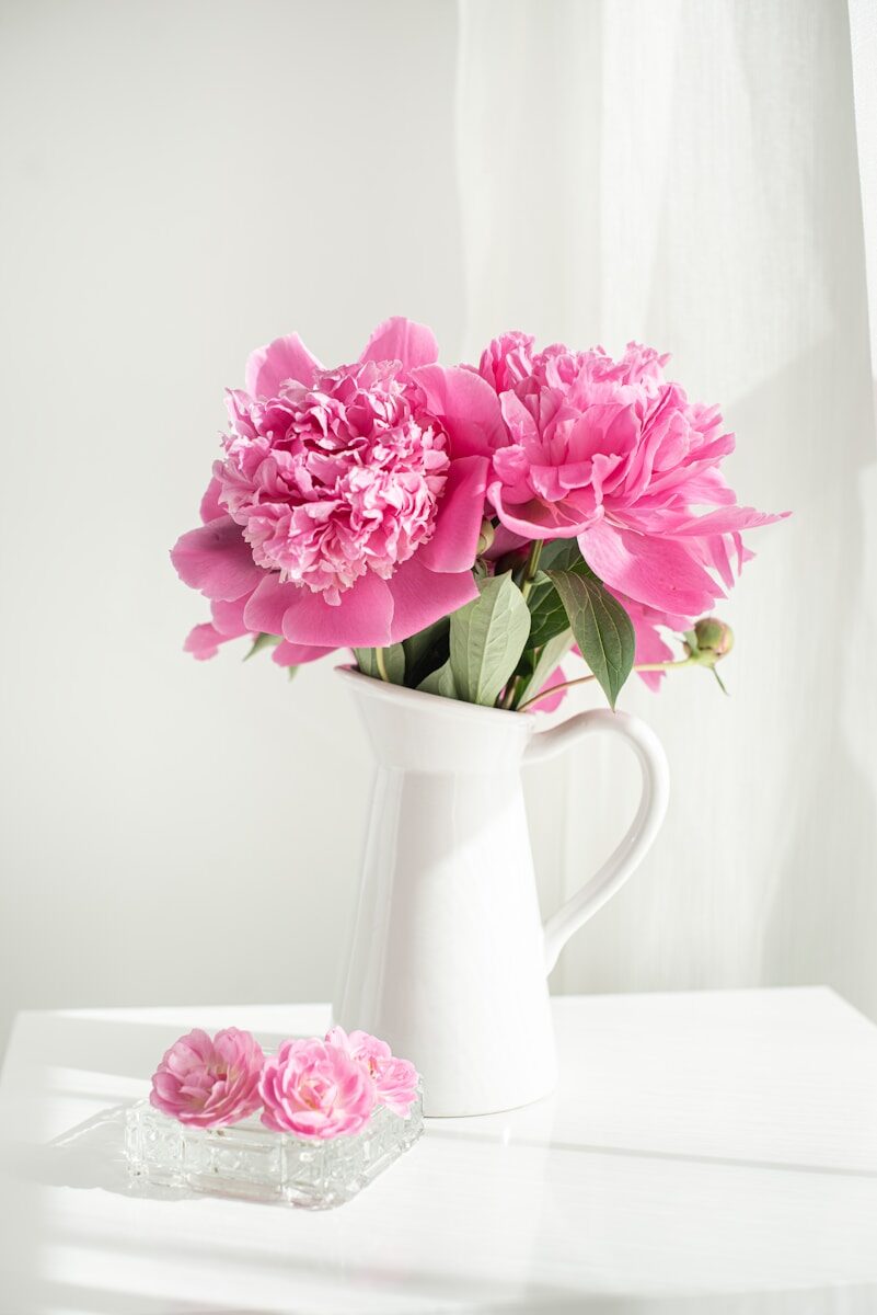 Accueil pink and white flowers in white ceramic vase